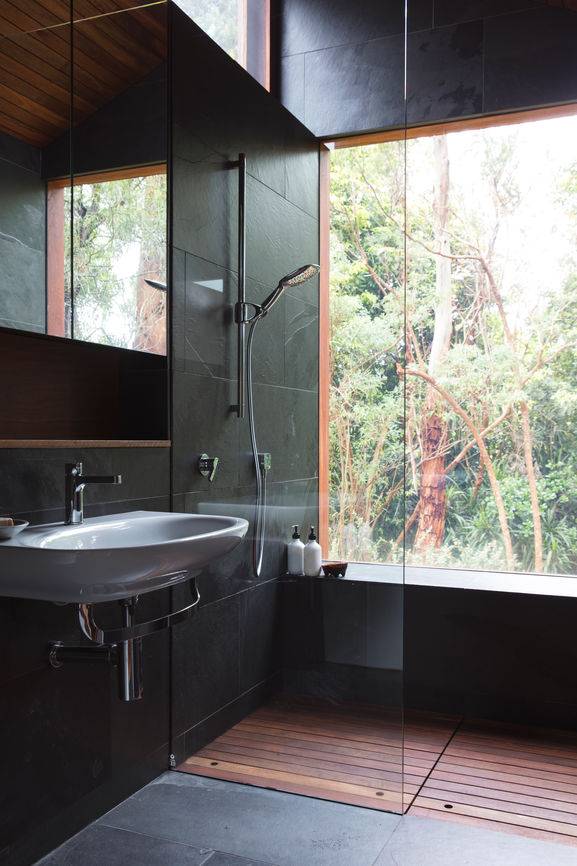Modernes Badezimmer mit schwarzen Fliesen und einem großen Fenster