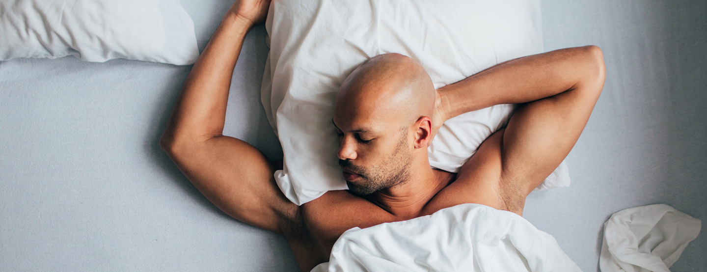 Mann mit Glatze im Seitenprofil schläft im Bett