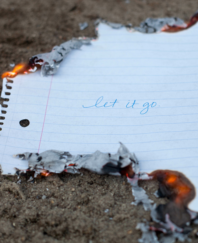 Zettel mit Schrift Let it go, der zur Sommersonnenwende verbrannt wird