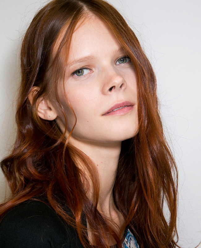 Hübsches Model mit rotem langen Haaren und leichten Wellen im Haar.