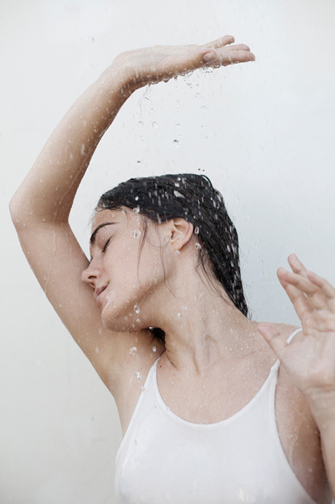 Frau mit nassem, dunklem Haar geniest den Regen