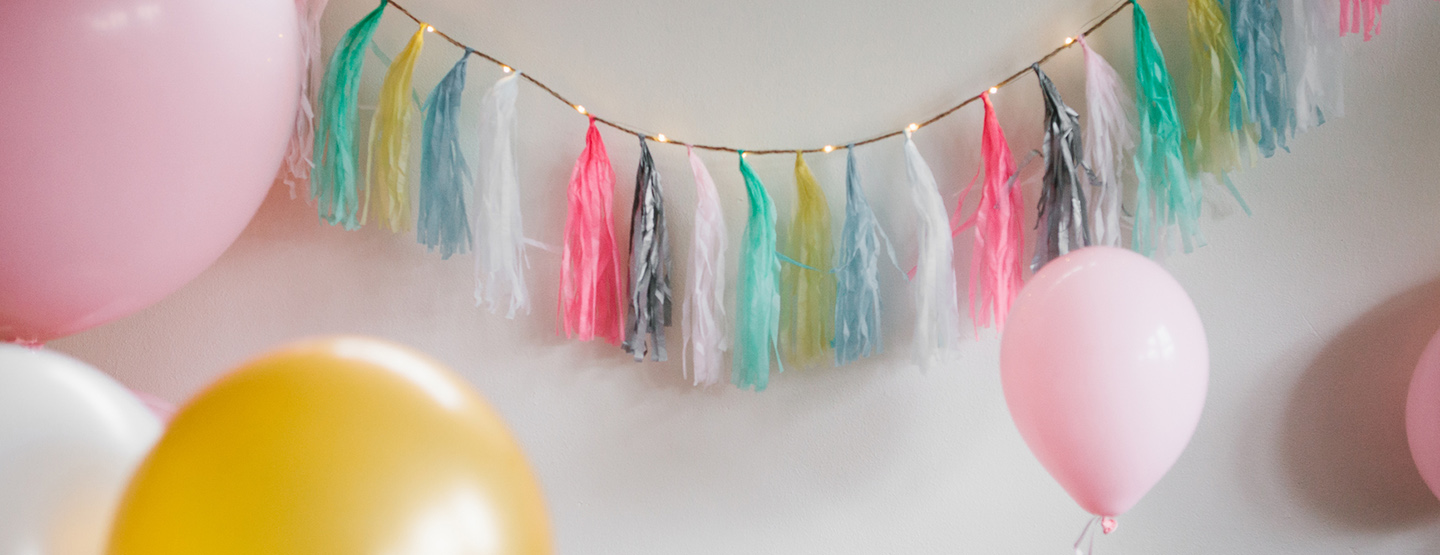 Partydekoration zur Geburt mit Luftballons und Lichterkette