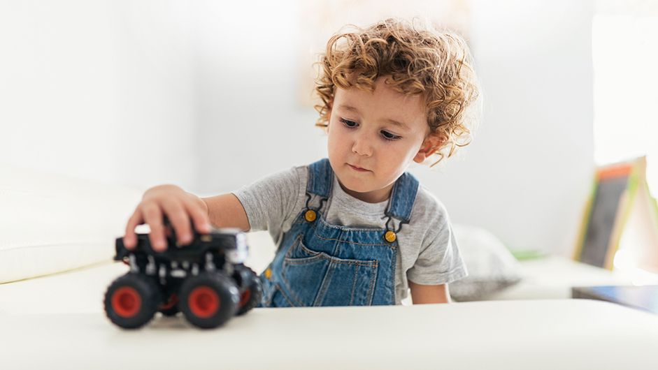 Kind spielt mit Spiel-Fahrzeug - möglicherweise bei der Eingewöhnung im Kindergarten