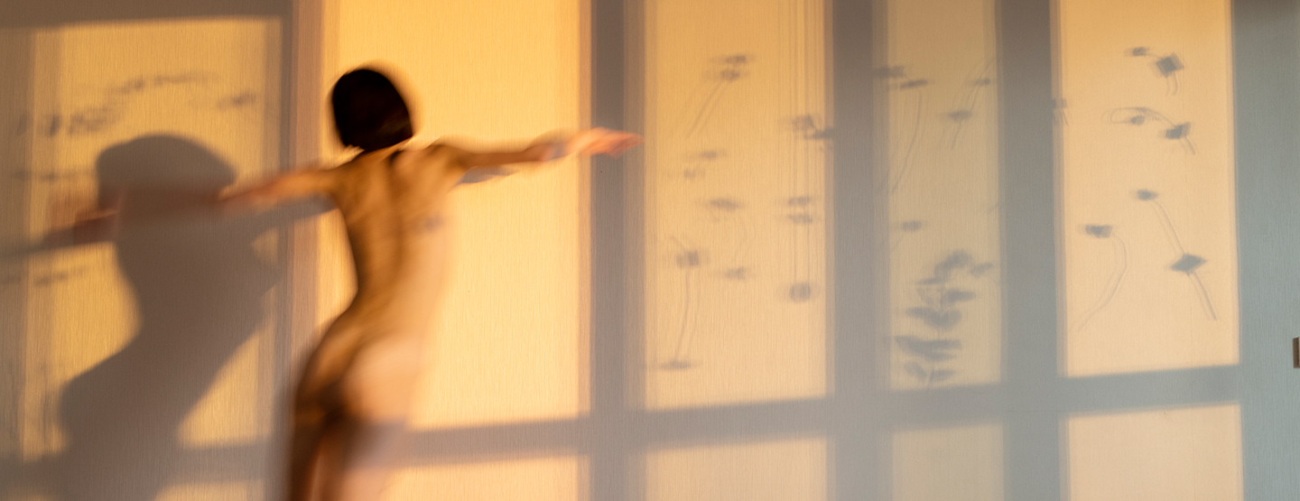 Frau tanzt nackt in der Wohnung im Abendlicht