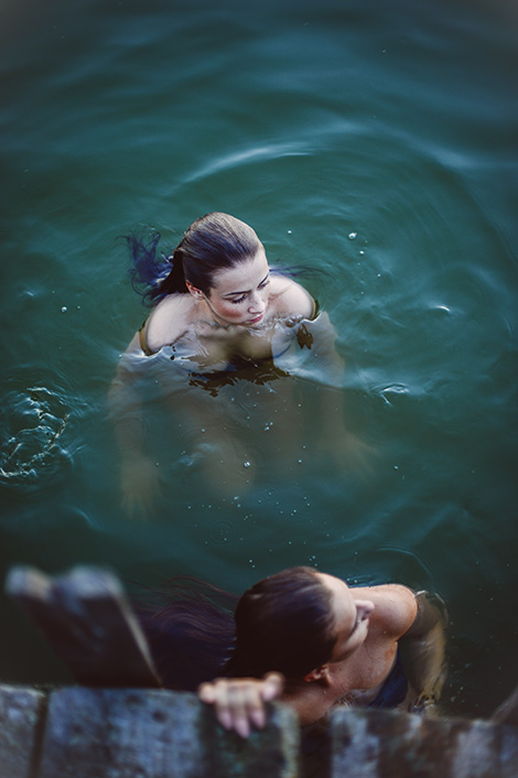 Zwei Frauen beim Eisbaden in einem See nahe eines Steges