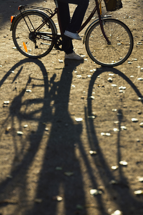 Stehender Fahrradfahrer wirft am Boden einen langen Schatten