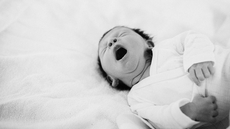 Schwarz-Weiß-Foto eines gähnenden Neugeborenen