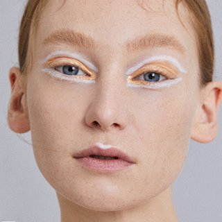 Frau mit orange-weiß geschminkten Augen