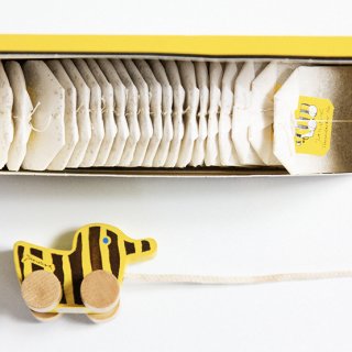 Teebeutel im Karton neben Tigerente aus Holz - Welcher Tee fürs Baby?