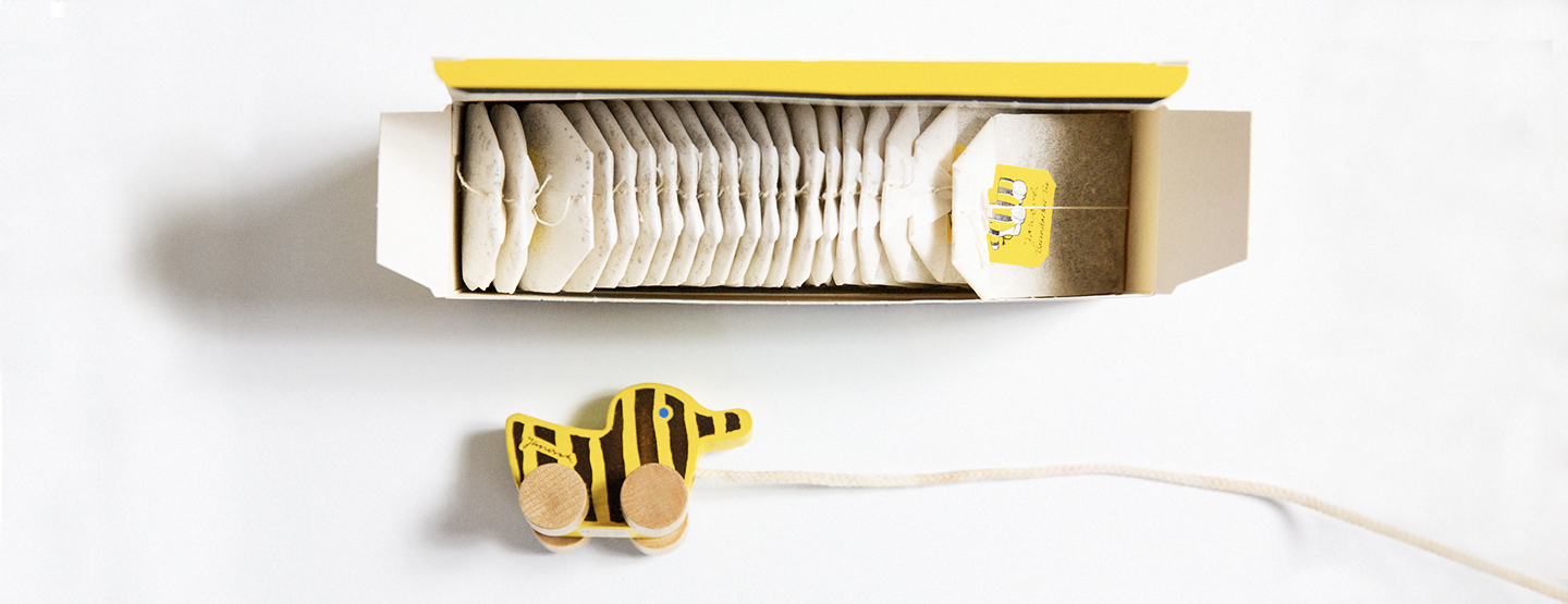 Teebeutel im Karton neben Tigerente aus Holz - Welcher Tee fürs Baby?