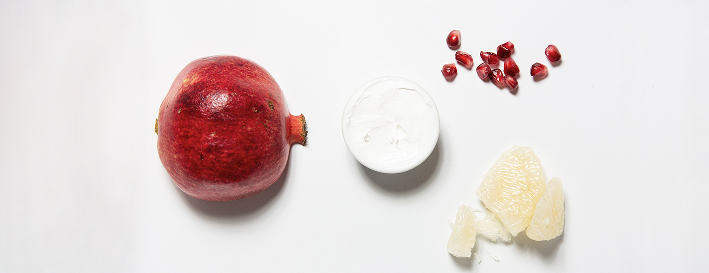 Granatapfel, Schälchen mit Antioxidantien-Creme und Fruchtfleisch einer Zitrone - Helfer im Kampf gegen freie Radikale