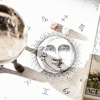 Stapel Tarotkarten und Kristallkugel auf einem Horoskop