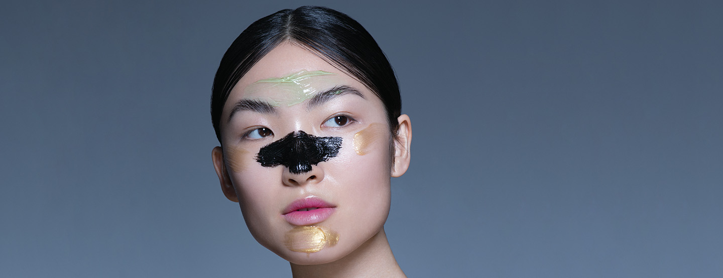 Asiatin mit bunten Farbklecksen im Gesicht - vielleicht Teil der K-Beauty