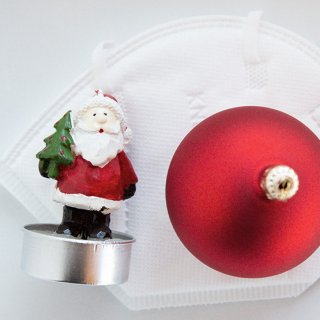 Weihnachten trotz Corona: FFP2-Maske mit Christbaumkugel und Weihnachtsmann
