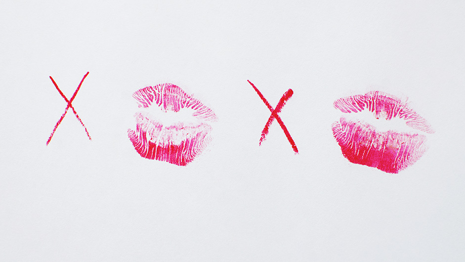 Xe und pinke Lippenstiftabdrücke auf weißem Hintergrund