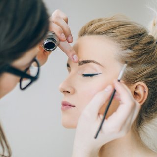 Junge Frau wird professionell von einer Make up-Artistin geschminkt