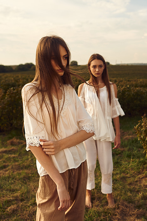 Zwei Frauen in weißen Blusen im Freien, die sich verzeihen wollen