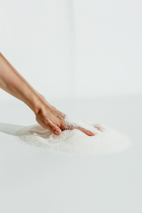 Frauenhand greift in einen Haufen Salz