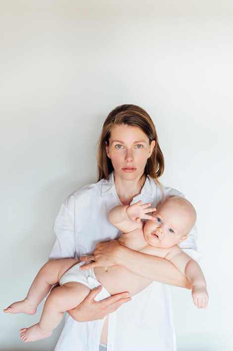 Frau mit Baby auf dem Arm, womöglich nach einer Geburt mit Dammriss