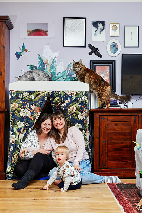 Ein lesbisches Paar mit ihrem Kind und zwei Katzen in ihrer Wohnung